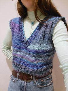 "This luxury silk mohair and wool v-beck sweater vest is handknit and features a boxy silhouette. The sweater is made of a wonderful silk and wool blend from Noro yarnss (45% silk, 45% mohair, 10% wool). I love the cool toned washes of purples, blues, grays, and mint greens that stripe through this sweater. The vest is meant to be slightly oversized and will fit womens size XS-M. The vest has a split hem on the sides.  Model is 5'6, 34\" bust, 27\" waist for reference. The vest is hand knit by m Light Green Sweater Vest Outfit, Colored Vest Outfit, Colourful Sweater Vest, Colorful Sweater Vest, Brown Knit Vest Outfit, Light Blue Sweater Vest Outfit, Wool Sweater Vest, Purple Sweater Vest Outfit, Crop Sweater Vest Outfit