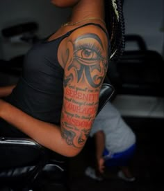 a woman's arm with an eye and words tattooed on the upper half of her arm