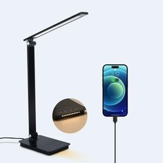 an image of a cell phone charging on a table with a lamp and charger