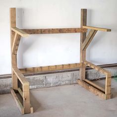 a bench made out of wooden planks sitting in a room next to a wall