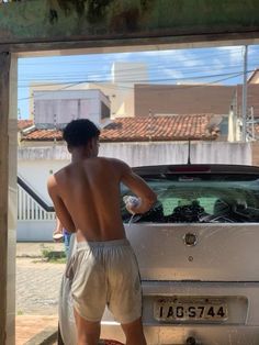 a man standing in front of a white car