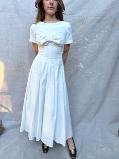 "Incredible 1950s Handmade White Velvet Dress / Big Bow at Bust / Center Back Zipper / Unlined which leaves room for letting out the waist seams if needed / Very Special One of a Kind / Perfect for Bridal / Full Sweep ! Measurements: Size XS - can be let out by tailor LAID FLAT Waist: 25\" Chest: 32\" Front Length from HPS: 48\" Shoulder: 13 1/2\" Sleeve Length: 7 1/8\" Sweep: 164\"  100% Velvet Condition:  Great vintage condition.  ** ALL SALES ARE FINAL , ask for detailed photos if needed **" Vintage Dresses With Bow And Short Sleeves, Vintage Formal Dress With Box Pleat, Vintage Short Sleeve Dress With Bow, 1950s Style A-line Vintage Dress For Daywear, 1950s Style Cream Vintage Dress, 1950s Style Cream Dress, Cream 1950s Style Vintage Dress, Vintage Dress With Box Pleat For Vintage Fashion, 1950s A-line Vintage Dress