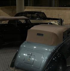 an antique car is on display in a museum with other old cars behind it,