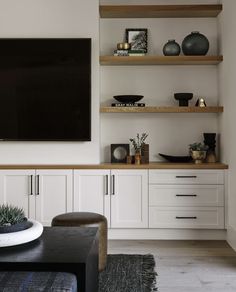 a flat screen tv mounted to the side of a white wall in a living room