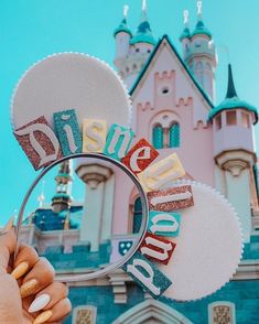 a person holding a magnifying glass in front of a castle with the word disney written on it