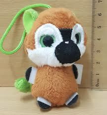 a small stuffed animal with big eyes sitting next to a measuring ruler on a table