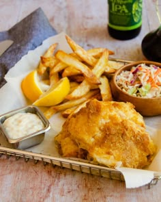 fish and chips with coleslaw, coleslaw salad and soda on the side