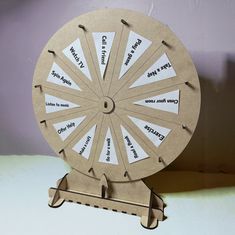 a paper wheel with words on it sitting on a table next to a purple wall