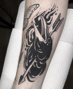 a black and white tattoo on the leg of a man with an arrow in it