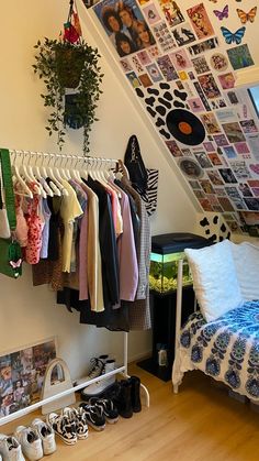 a bedroom with clothes hanging from the ceiling and shoes on the floor next to it