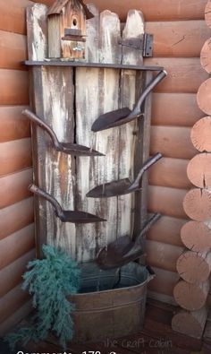 a birdhouse is on the corner of a wooden wall next to a potted plant