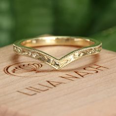 a gold wedding band sitting on top of a wooden box