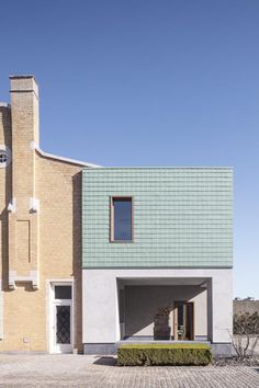 the house is made out of bricks and has a green roof