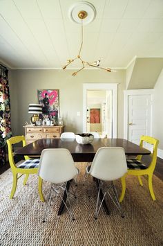 a dining room table with four chairs and a black and white checkered rug on the floor