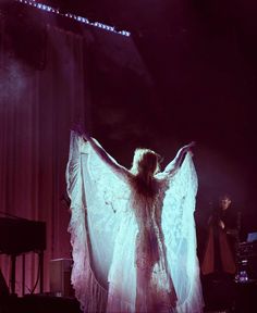 a woman in white dress standing on stage