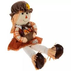 a stuffed doll sitting on top of a white floor next to a brown and orange hat