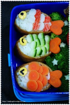 two pieces of bread with fish and veggies on them in a blue container