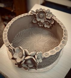 there is a decorative bowl with flowers on the top and bottom, sitting on a table