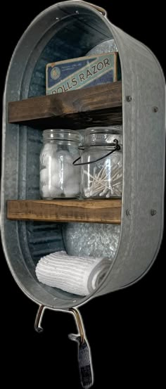 an open metal container with some jars and towels on it's shelf next to a towel rack