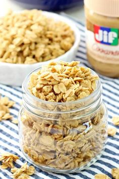 two jars filled with granola sitting on top of a blue and white table cloth