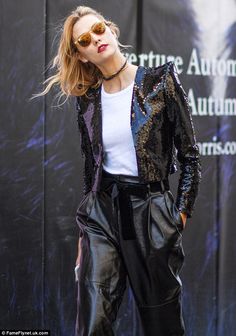 a woman in black leather pants and white shirt