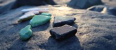 three pieces of chocolate sitting on top of a sandy beach covered in sand and rocks