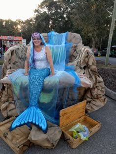 a woman sitting on top of a fake mermaid