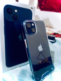 two iphones sitting next to each other on top of a blue tablecloth covered surface