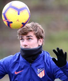 a young man is balancing a soccer ball on his head in preparation to kick it