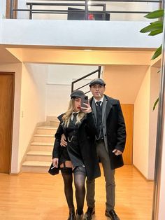 a man and woman standing in front of a staircase taking a selfie with their cell phone