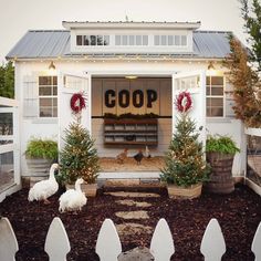 two chickens in front of a coop with christmas decorations