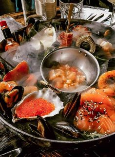 a platter filled with assorted seafood and sauces on top of a table