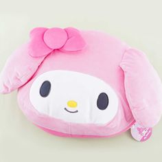 a pink stuffed animal with a bow on it's head is laying next to a white wall