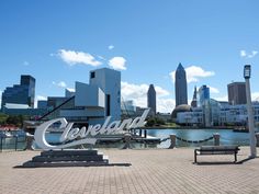 there is a large sign that says cleveland in front of the city's skyline