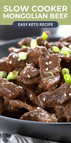 slow cooker beef with sesame seeds and green onions in a black bowl on a table