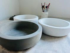 two white bowls sitting on top of a table