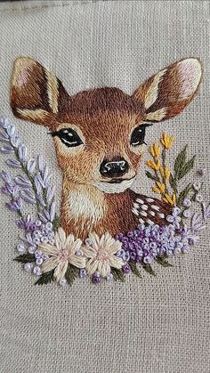 an embroidered deer with flowers on it's chest