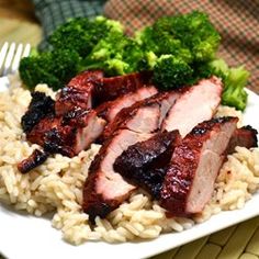 some meat and rice on a plate with broccoli