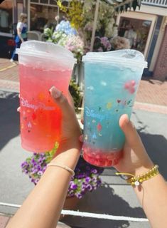 two people holding up drinks in their hands