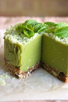 there is a green cake with mint leaves on the top and one slice cut in half