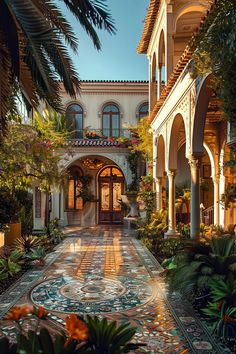 a large house with lots of plants and flowers in front of the entrance to it