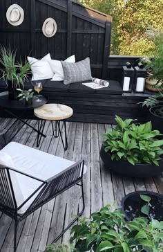 an outdoor deck with chairs, tables and potted plants