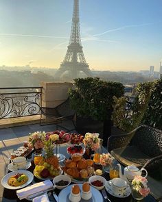 a table full of food with the eiffel tower in the background