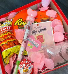 a red box filled with candy, candies and other things to make it look like valentine's day