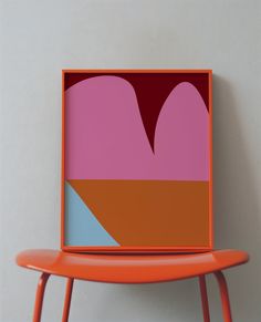 an orange chair sitting in front of a pink and blue heart shaped painting on the wall