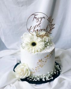 a wedding cake with white flowers and a name on top that says f is for khle