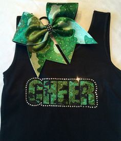 a black tank top with green glitter letters and a bow