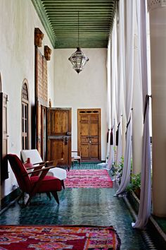 an instagram photo of a living room with red chairs and rugs on the floor