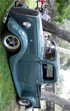 an old car is parked on the grass