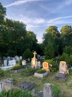 a cemetery with many headstones and trees in the background